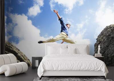 Businessman jumping over the mountains, business concept Wall mural