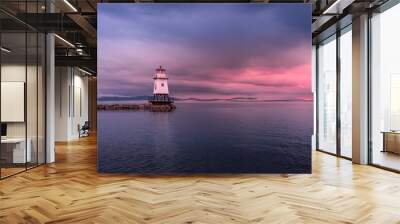 The Burlington Lighthouse before the storm under a cloudy, colorful sky at sunset. The sky is threatening. On the horizon, we can see that the clouds are low. Wall mural