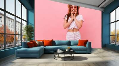 Photo of young surprised beautiful woman standing isolated over pink background. Looking camera. Wall mural