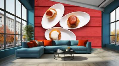 patatas bravas stuffed with meat with spicy sauces on red wood Wall mural