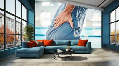 Pain in back, sports and man by swimming pool with injury, muscle ache and inflammation from training. Health, medical care and male with accident, emergency or body bruise from fitness or exercise Wall mural