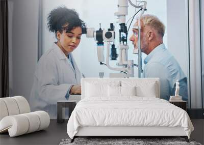 Vision, eye exam and writing with a doctor woman or optometrist testing the eyes of a man patient in a clinic. Hospital, medical or consulting with a female eyesight specialist and senior male Wall mural