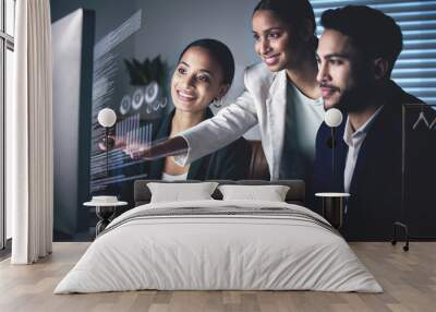 Interactive business is the future. Shot of a young group of businesspeople using a computer while working in the office at night. Wall mural