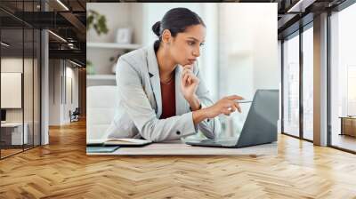 Serious, laptop and professional businesswoman sitting and reading a work email with a pen working from home. Business, computer and focused female lawyer in modern office preparing for a case. Wall mural