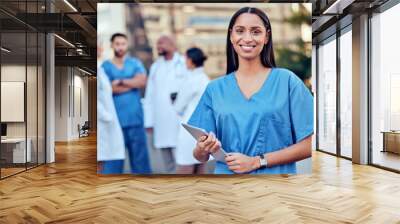 Shes ready to work. Shot of a young female doctor using a digital tablet in the city. Wall mural