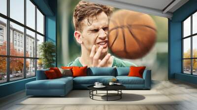 Sports, basketball and accident with face in game match on athlete court for tournament training. Injured man in professional outdoor fitness centre in pain from impact of ball hit action. Wall mural