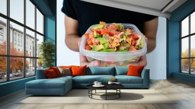 Hands holding a healthy mediterranean pasta salad tupperware Wall mural