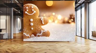 A gingerbread man is smiling and standing on a snowy surface Wall mural