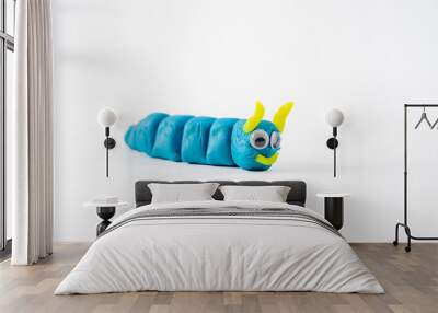 selected focus on head and antenna plasticine play dough wriggly worm in blue and yellow isolated on a white background with copy space Wall mural