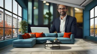 Portrait of a successful male businessman, banker, financial director sitting in the office at the table and using a laptop. Looking and smiling at the camera
 Wall mural