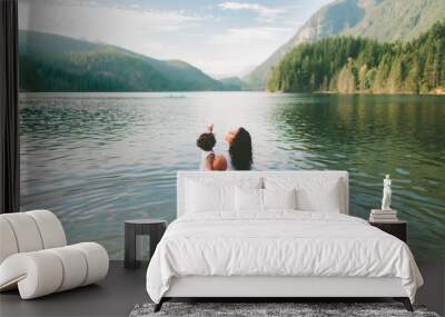 A mother and daughter exploring a beautiful lake in the mountains Wall mural