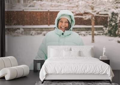 A senior woman in a winter jacket in the snow. Wall mural