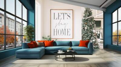 A simply decorated home at Christmas and a sign that says 'let's stay home'.  Wall mural