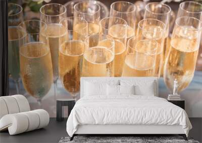 Glasses of chilled champagne stand on a table with a tablecloth for a welcome treat for guests of the event Wall mural