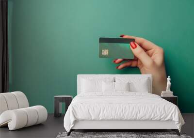 Female hand holding credit card on green background Wall mural