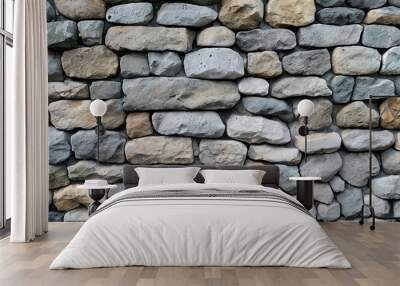 A close-up view of a rustic stone wall, featuring a variety of irregularly shaped stones. The stones are a mixture of grey, brown and beige. Wall mural