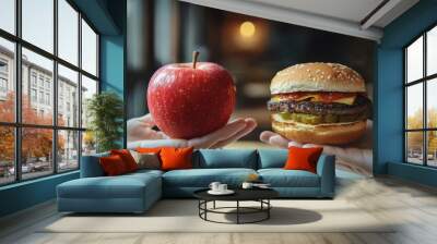 Comparison of a healthy apple and a tempting hamburger in hand Wall mural