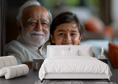 Happy Indian elderly great grandpa and great granddad watching cute little granddaughter kid, enjoying childcare, family leisure, sitting on white sofa together in cozy home living room, Generative AI Wall mural