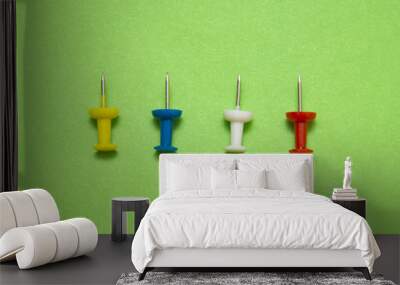 Set of push pins in different colors, isolated on green backgrou Wall mural