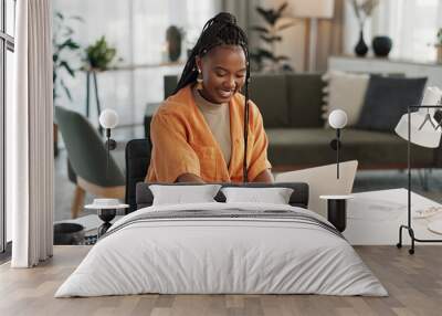 Black woman, typing in home office and laptop for research in remote work, social media or blog in apartment. Freelance girl at desk with computer writing email, website post and online chat in house Wall mural