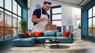 Chef, baking and cake with chocolate in a kitchen by a happy man preparing a sweet desert or a birthday. Decoration, baker or cook with a small business smiling and cooking dessert at a bakery Wall mural