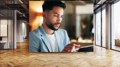 Confident business planning a marketing strategy on a digital tablet while working in a modern office. Young professional using an online app to manage time and balance his tasks, a list for success Wall mural