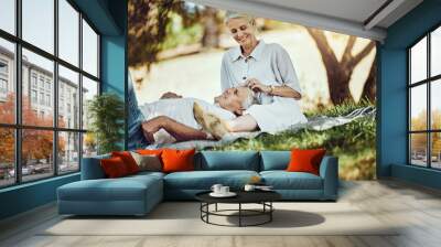 Retirement, love and picnic with a senior couple outdoor in nature to relax on a green field of grass together. Happy, smile and date with a mature man and woman bonding outside for romance Wall mural