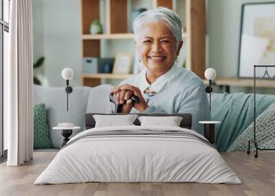 Woman, senior and portrait with cane on sofa, walking support and assistance stick in retirement home on weekend break. Smile, happiness and elderly female person with a disability, wellness and help Wall mural