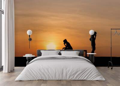 Silhouettes of couple man and woman broken heart at nature sunset. Love concept. Wall mural