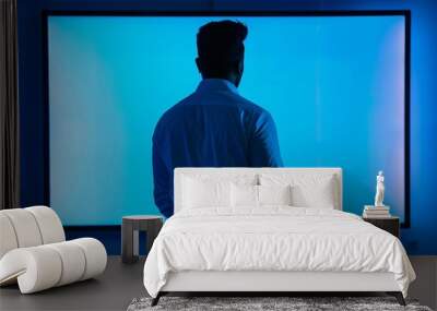 App demo indian man in his 40s in front of a interactive digital board with an entirely blue screen Wall mural