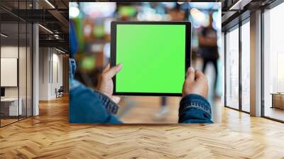 App display looking over a shoulder of a adult man holding a tablet with a completely green screen Wall mural