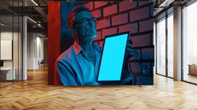 Digital mockup over a shoulder of a middle-aged man holding an ebook with a completely blue screen Wall mural