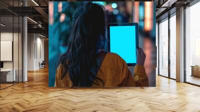 Digital mockup over a shoulder of a teen girl holding an ebook with a completely blue screen Wall mural