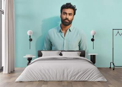 portrait of a content indian man in his 30s sporting a versatile denim shirt against a pastel teal b Wall mural