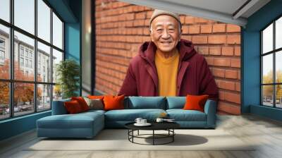 Portrait of a glad asian man in his 80s sporting a comfortable hoodie against a vintage brick wall. AI Generation Wall mural