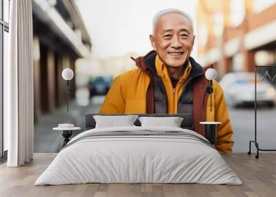 Portrait of a grinning asian man in his 60s sporting a stylish varsity jacket over white background Wall mural