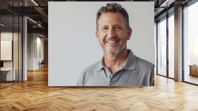 Portrait of a happy caucasian man in his 30s donning a classy polo shirt in front of minimalist or empty room background Wall mural