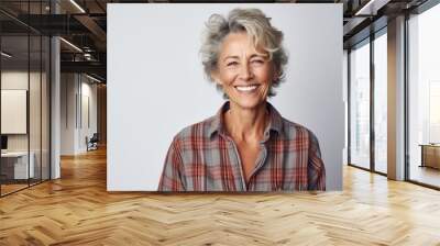 Portrait of a happy woman in her 60s wearing a comfy flannel shirt isolated on white background Wall mural