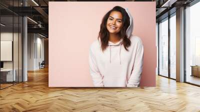 Portrait of a smiling woman in her 20s sporting a comfortable hoodie against a pastel or soft colors background. AI Generation Wall mural