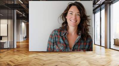 Portrait of a smiling woman in her 40s dressed in a relaxed flannel shirt isolated on white background Wall mural