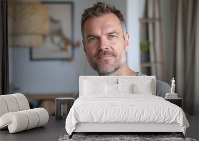 Portrait of a tender caucasian man in his 40s dressed in a casual t-shirt isolated on crisp minimalistic living room Wall mural