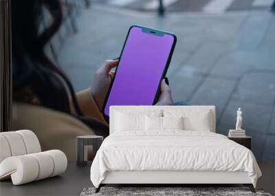 Ui mockup woman in her 30s holding an smartphone with a completely purple screen Wall mural