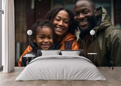 Portrait of a smiling African American family in rain with raincoats Wall mural