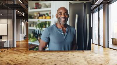 Portrait of a smiling middle aged fit man in modern kitchen with fresh vegetables Wall mural