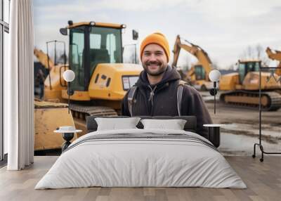 Portrait of a young man standing next to heavy machinery on construction site Wall mural