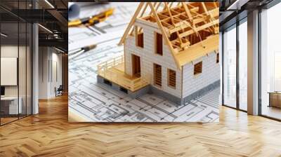 Image shows a toothpick model house on architectural drawings, with tools like pencils. Depicts a professional architectural setting with detailed construction plans. Wall mural