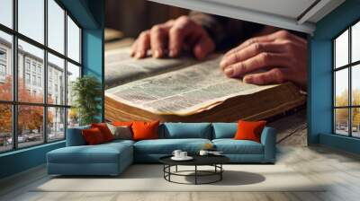 A man sitting by an open Bible is engrossed in prayer Wall mural