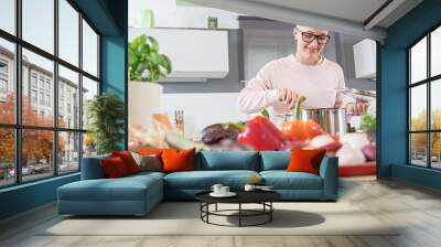 Smiling young woman, cooking with vegetables Wall mural