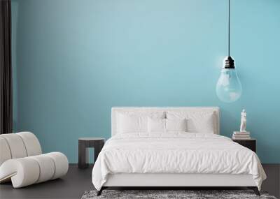 Singular hanging light bulb on bright blue background with space for text Wall mural