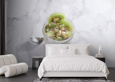 Overnight oats with chia seeds, kiwi and yogurt, on a white marble background. Wall mural